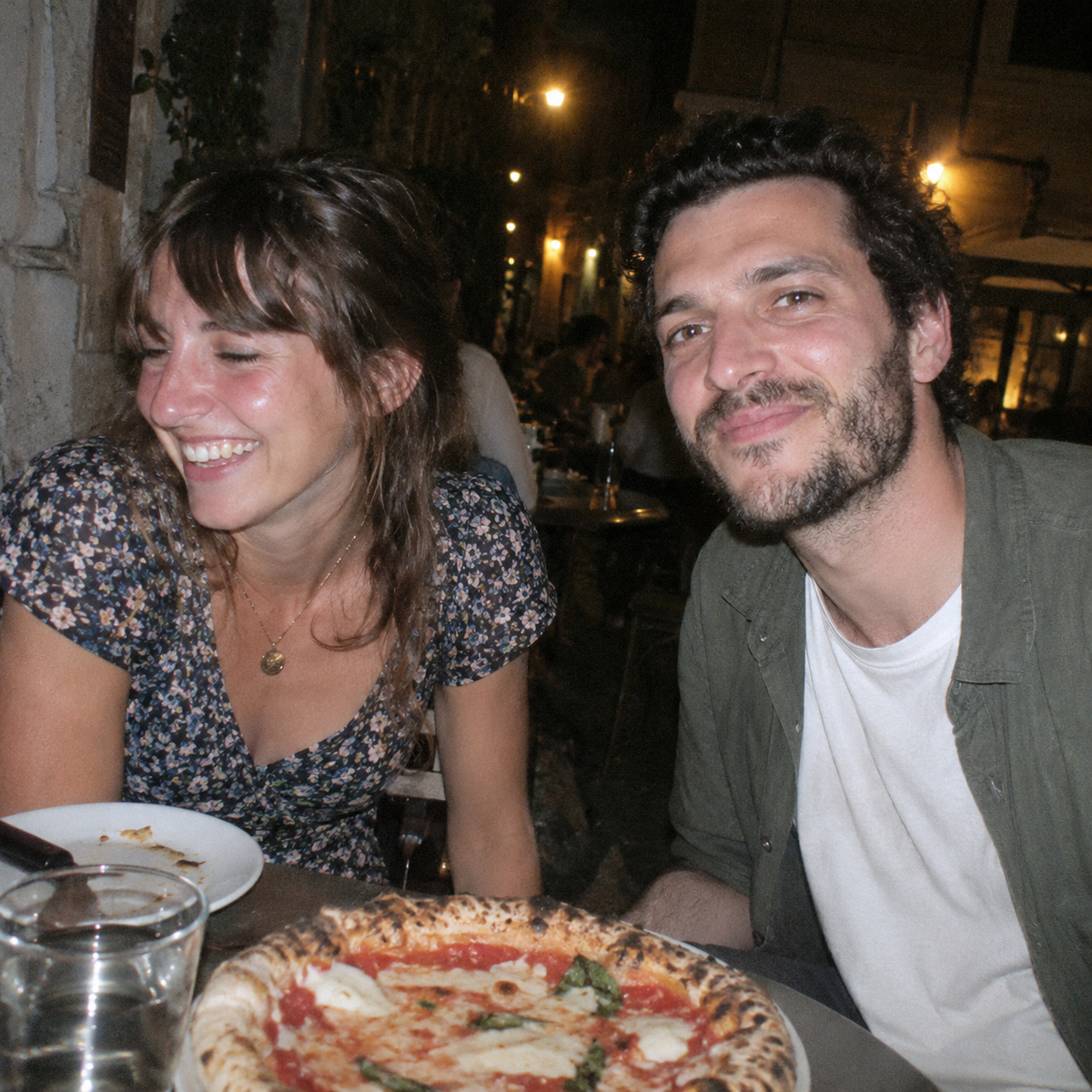 Deux amis à une table de terrasse le soir, ambiance pellicule au flash